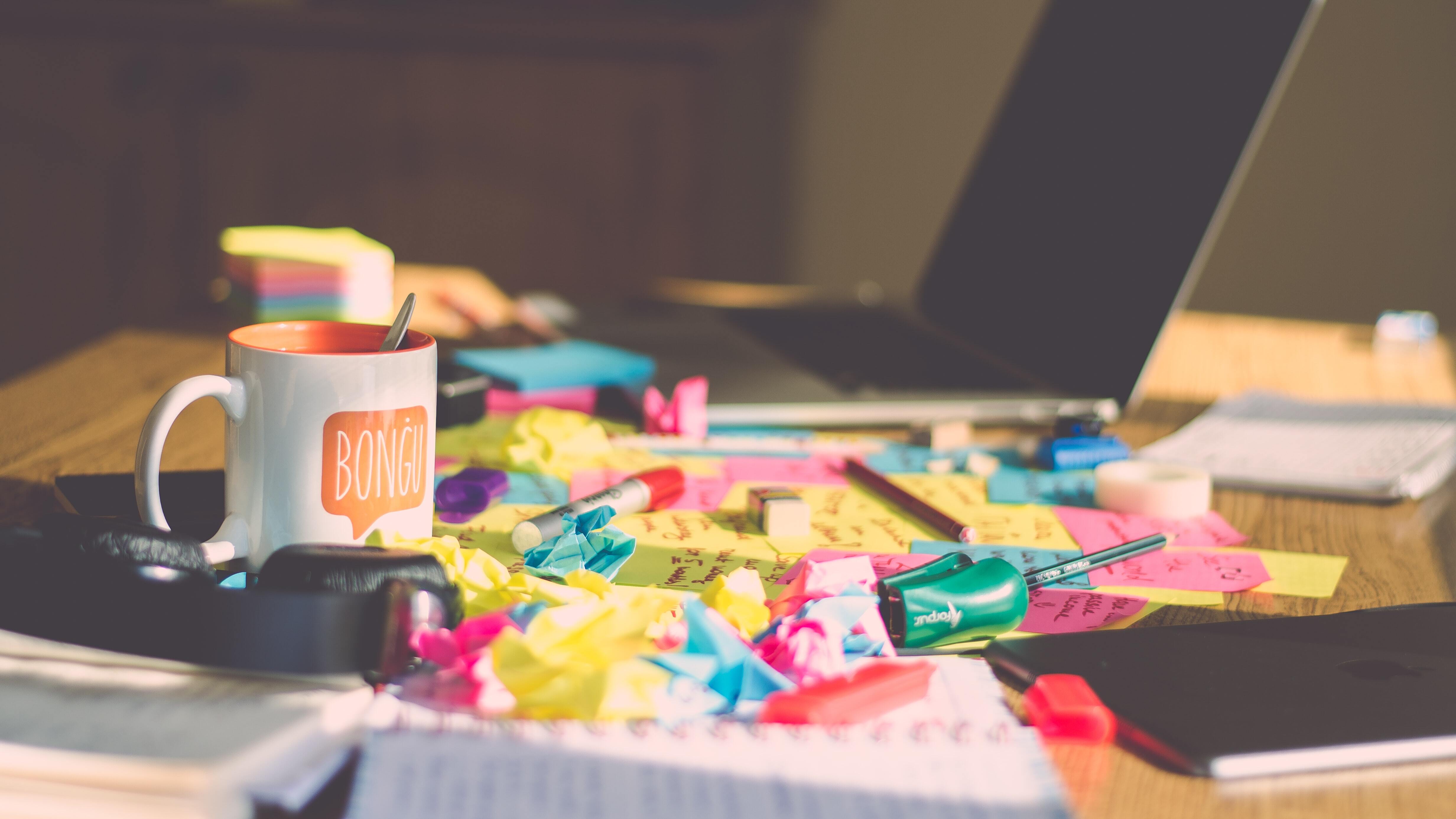 A messy desk with sticky notes