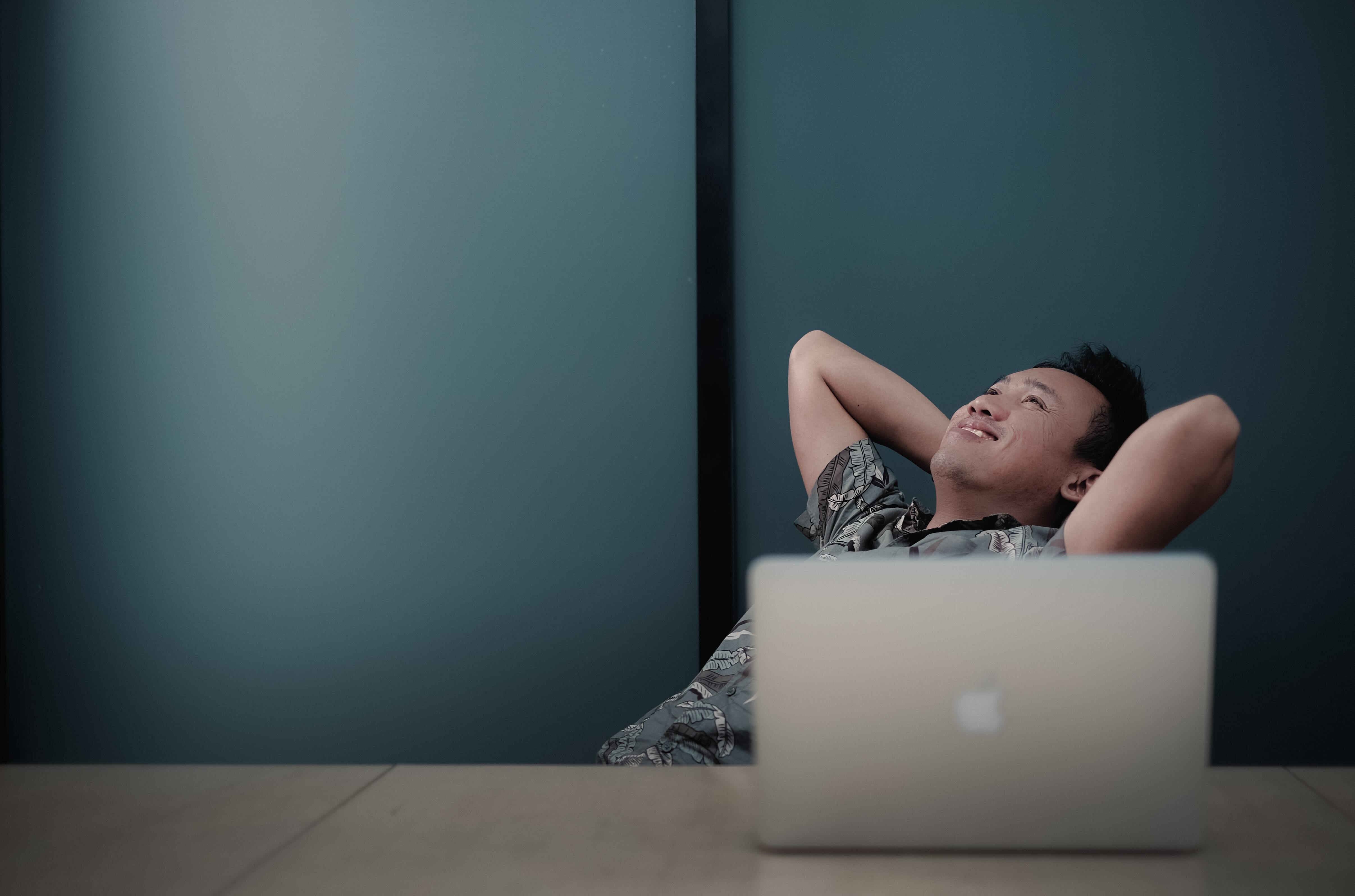 Man relaxed and content at work with laptop