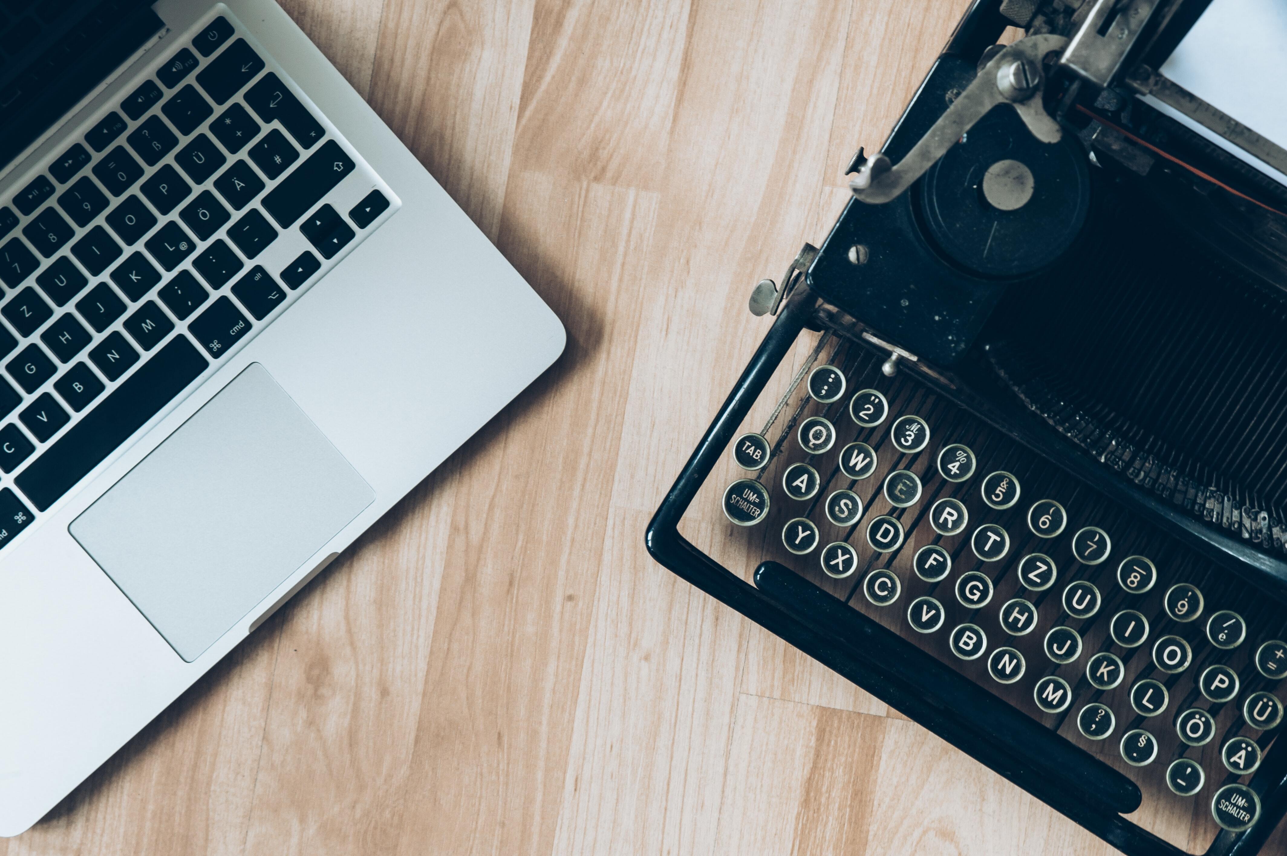 laptop next to typerwriter