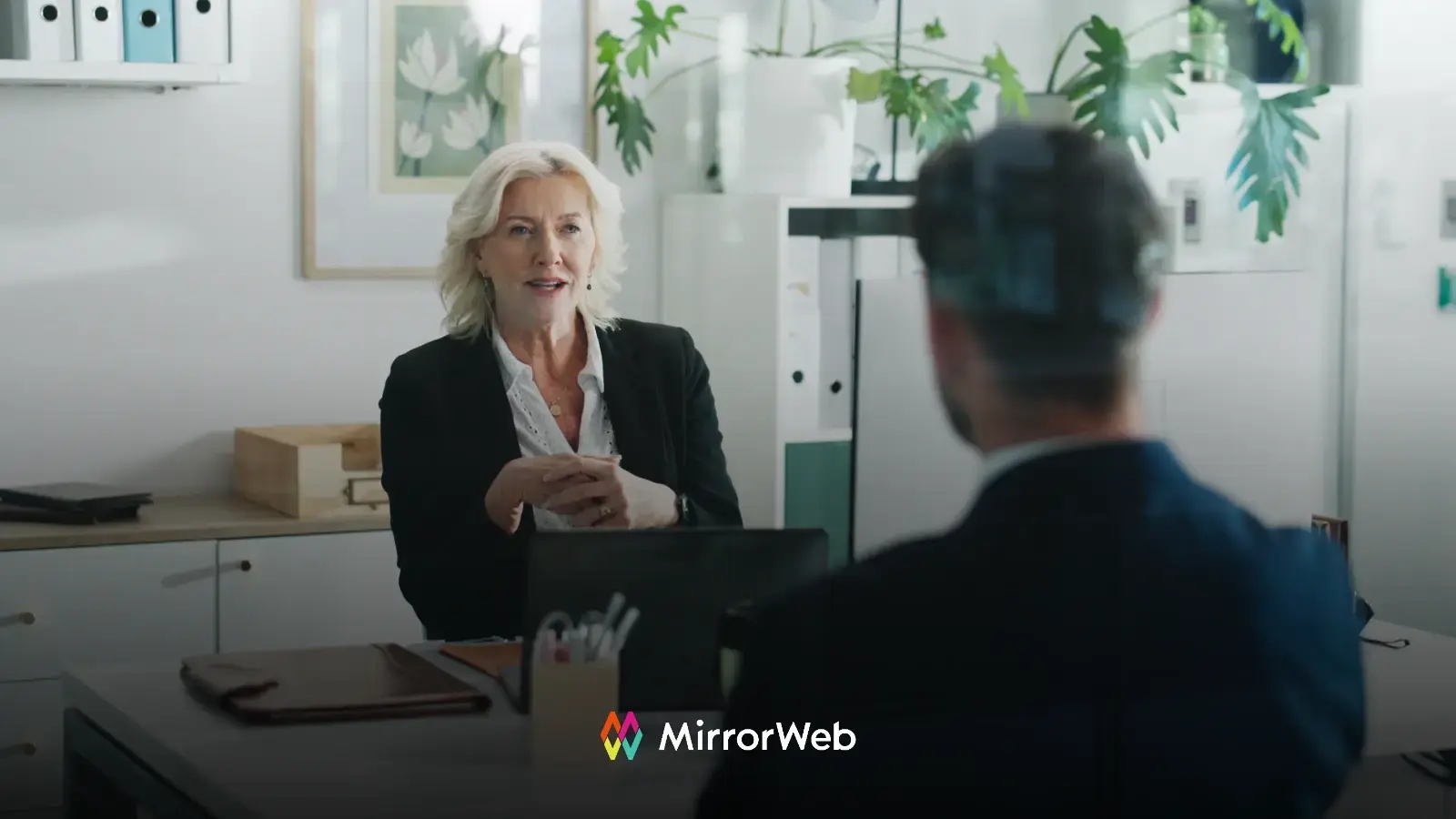 A compliance professional conducting a vendor evaluation meeting across a desk, representing the due diligence process for selecting an AI communications supervision solution