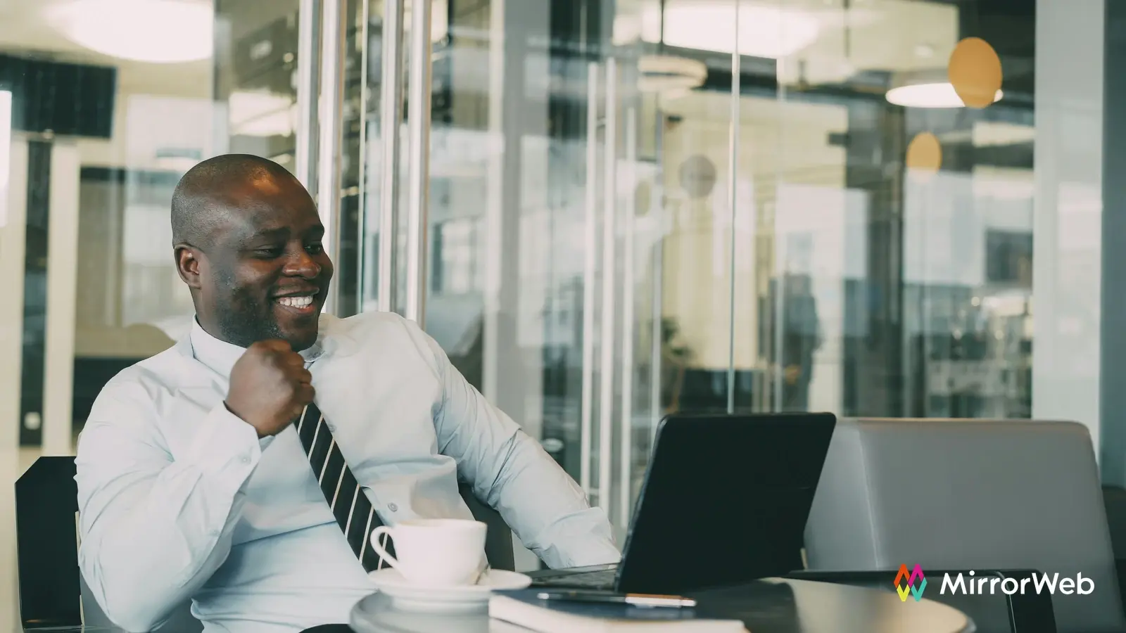 Compliance officer relaxed at desk with laptop and coffee